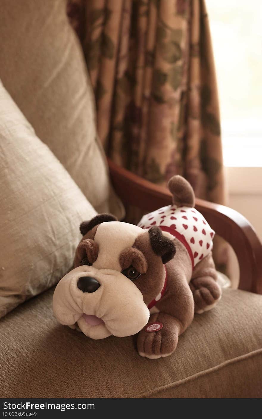 Stuffed dog toy sits on a chair inside of a house