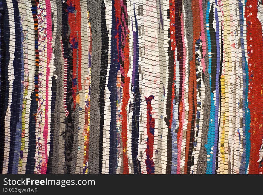 Multicolored rug, made of different pieces. Frontally, a fragment, closeup.