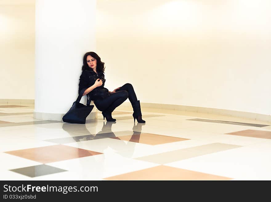 Woman with a bag sitting with his elbows, look distance