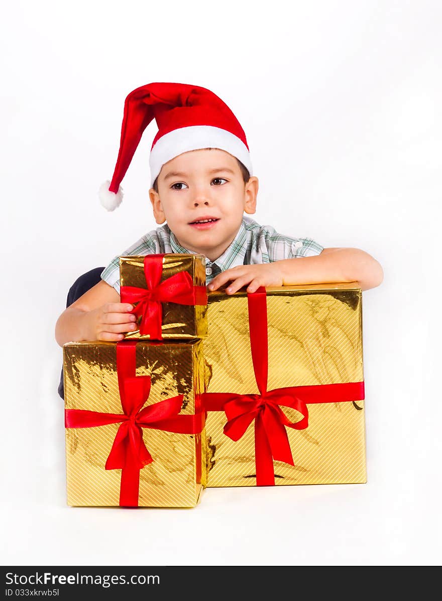 Happy little boy in Santa hat with a bunch of gifts, holiday Christmas, New Year