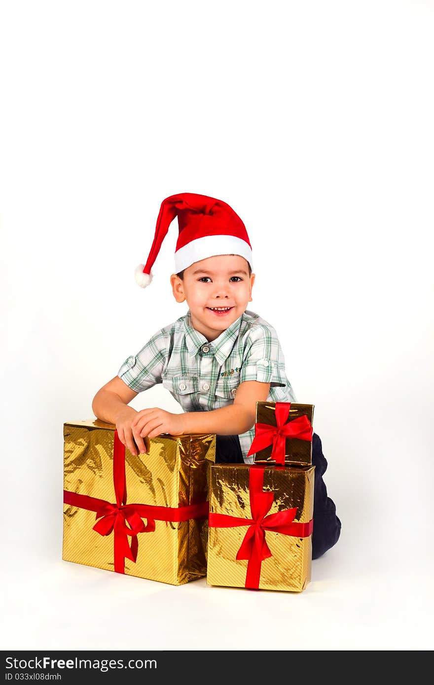 Happy little boy in Santa hat with a bunch of gifts, holiday Christmas, New Year