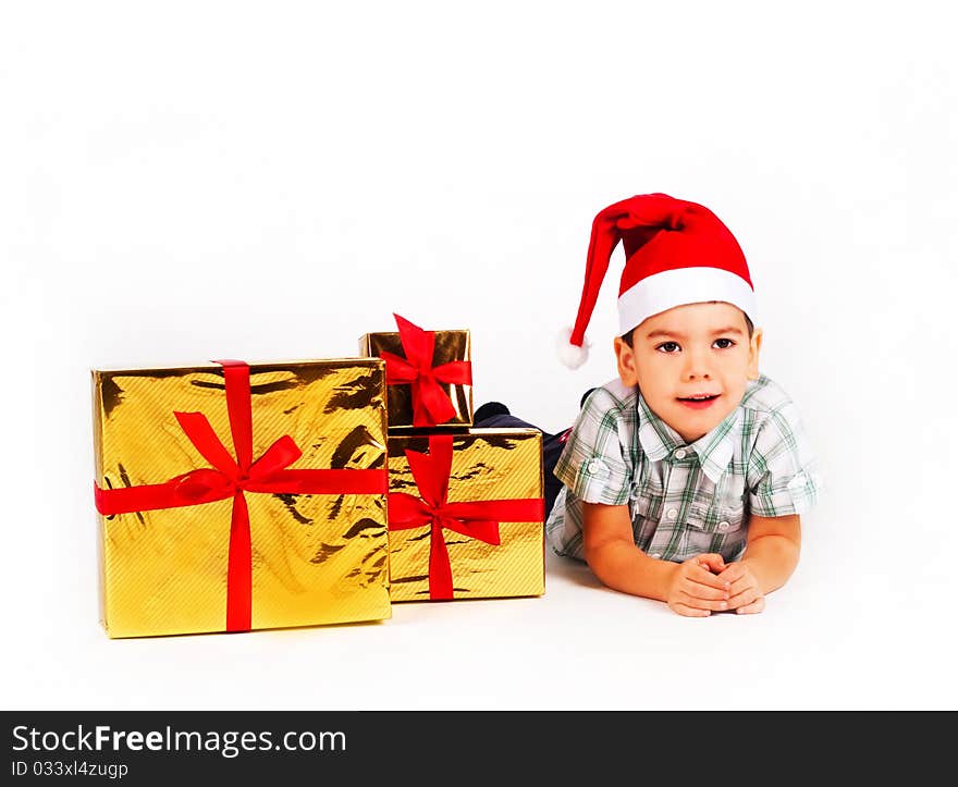 Happy little boy in Santa hat with a bunch of gifts, holiday Christmas, New Year