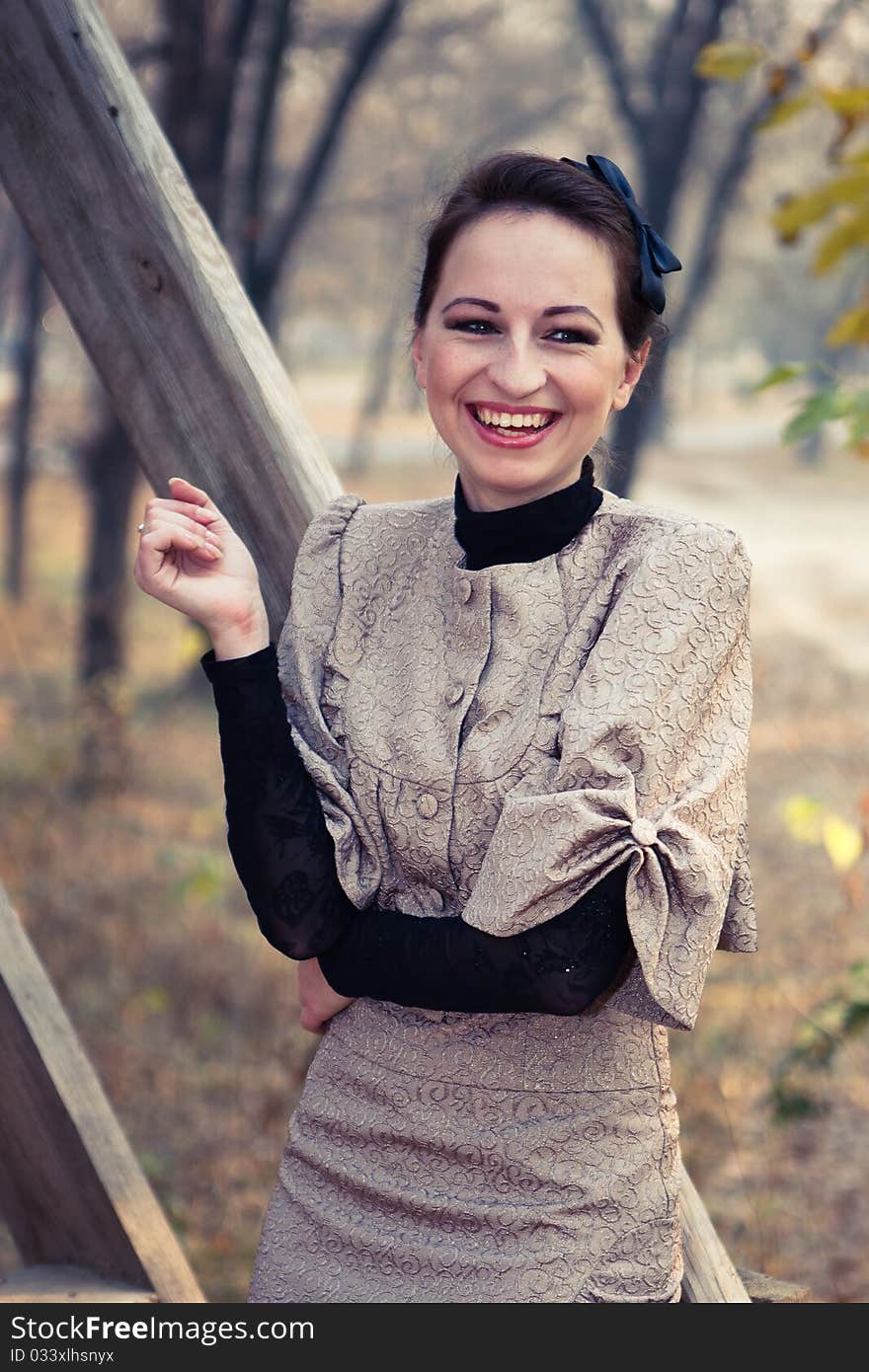 A woman in an old dress on a walk near the wooden railing