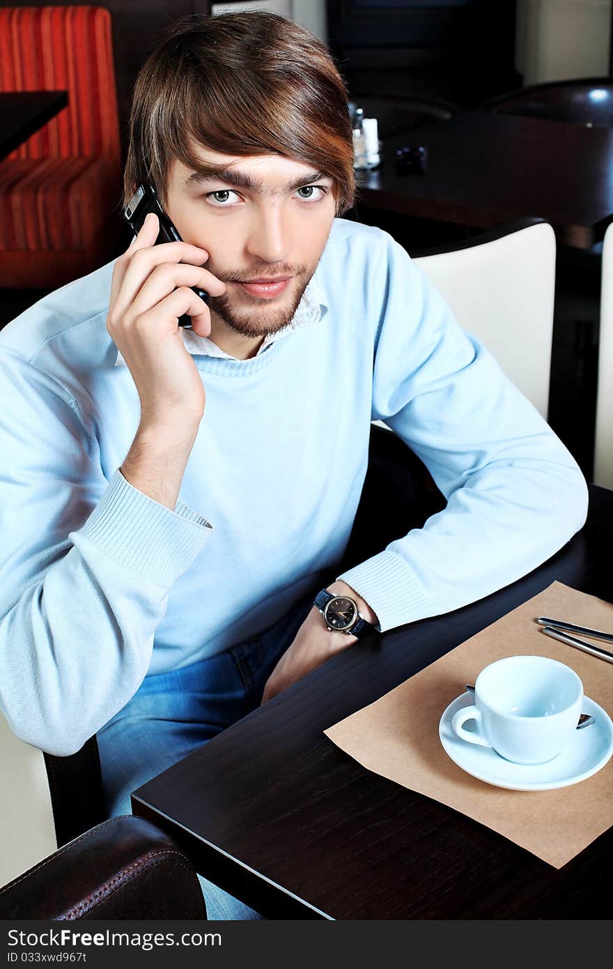 Young business man having a break at a café. Young business man having a break at a café.