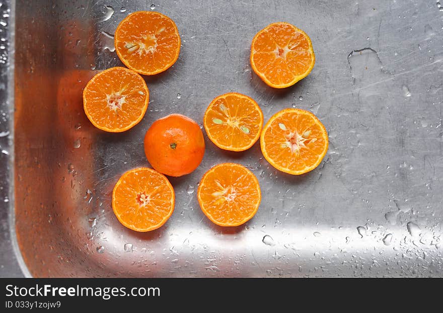 Cut oranges in a kitchen sink ready to be squeezed. Cut oranges in a kitchen sink ready to be squeezed