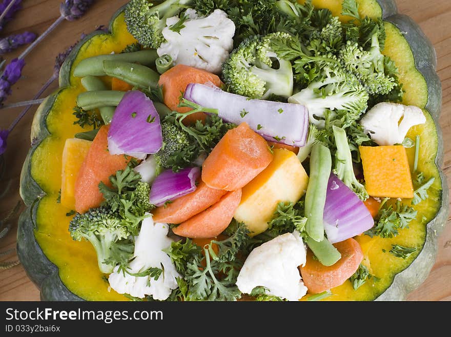 Mixed raw uncooked vegetables and spices stuffed in a pumpkin. Mixed raw uncooked vegetables and spices stuffed in a pumpkin