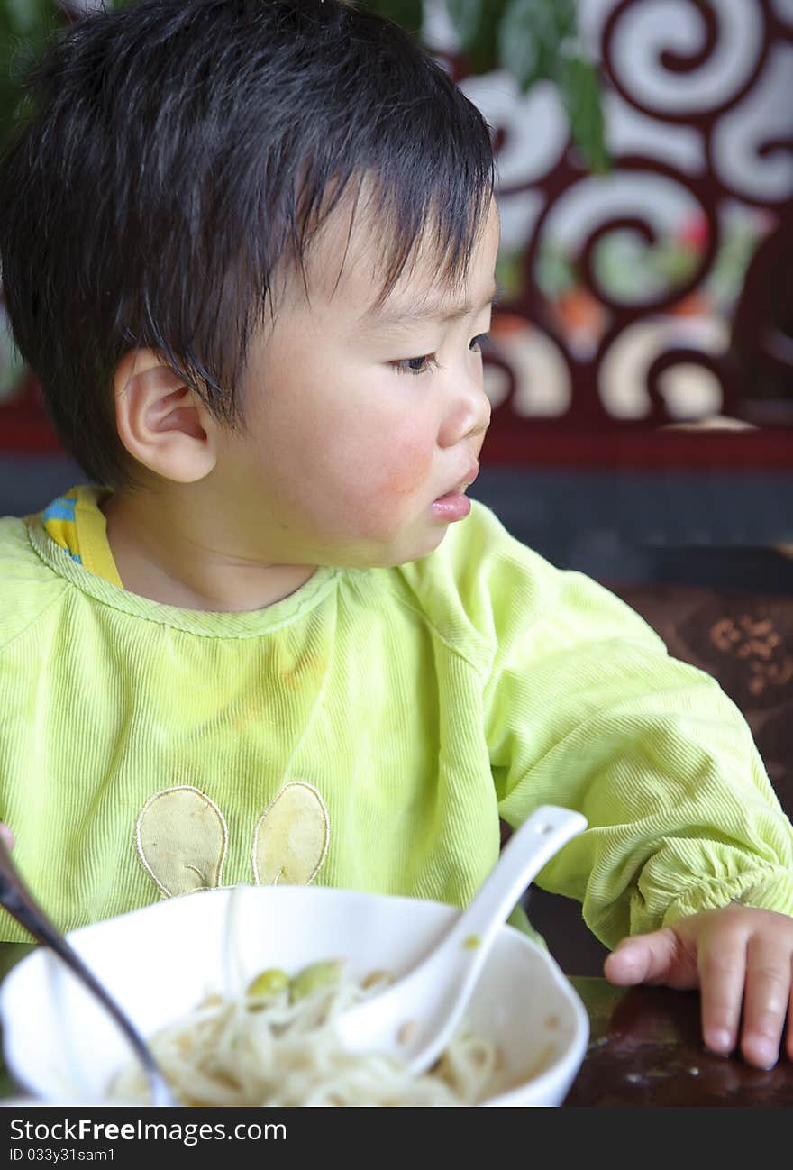 A cute baby is eating in a restaurant. A cute baby is eating in a restaurant.