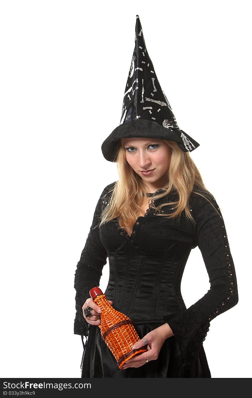 A young woman in a witch costume with a bottle. A young woman in a witch costume with a bottle