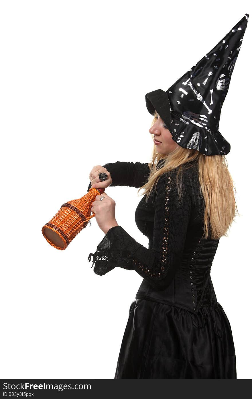 A young woman in a witch costume with a bottle. A young woman in a witch costume with a bottle