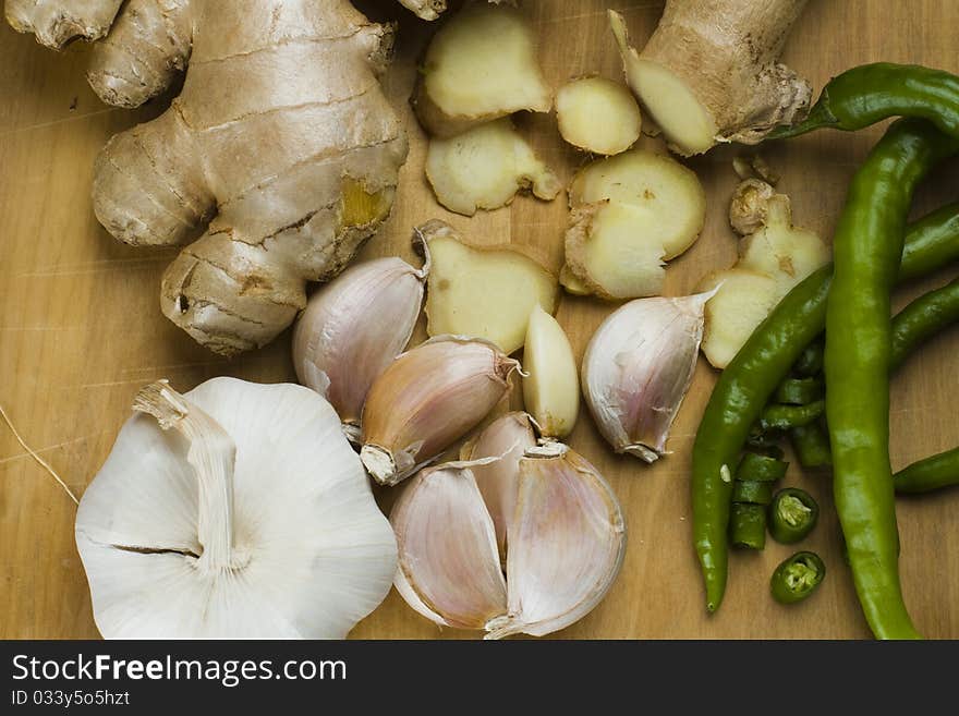 Freshly cut garlic cloves and fresh ginger rhizome with green chillies. Freshly cut garlic cloves and fresh ginger rhizome with green chillies