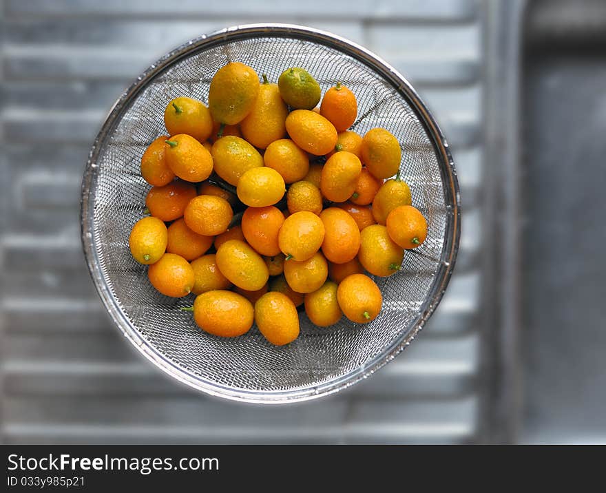 Baby oranges rinsed waiting to be mixed as salad ingredient. Baby oranges rinsed waiting to be mixed as salad ingredient