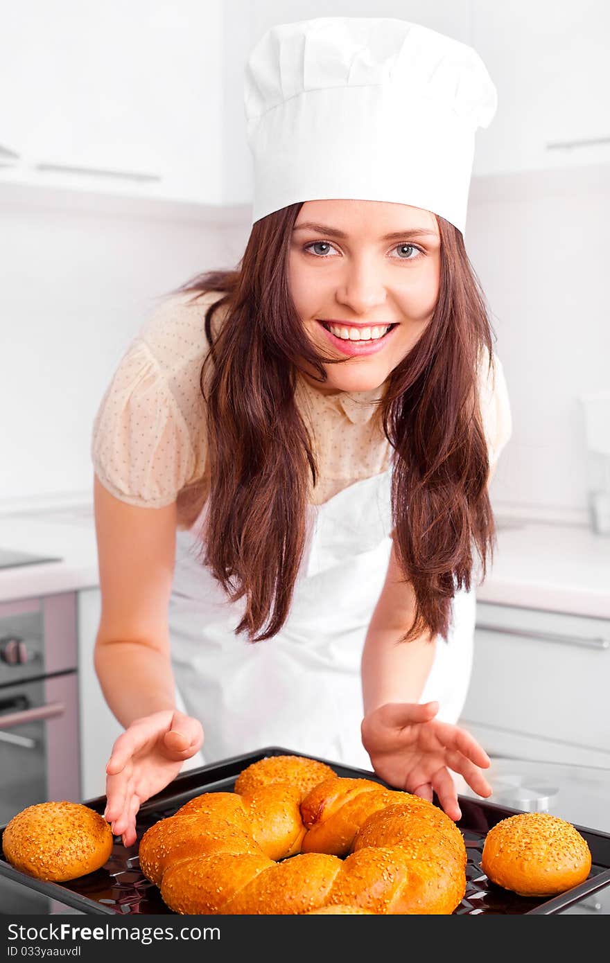 Beautiful young woman baking bread in the kitchen