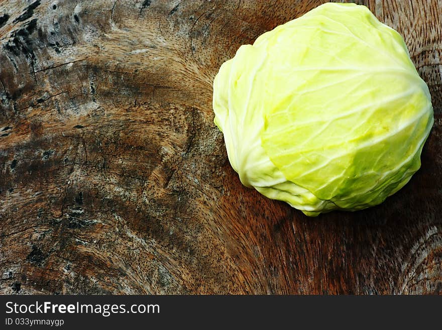 Green cabbage on wooden chopping board