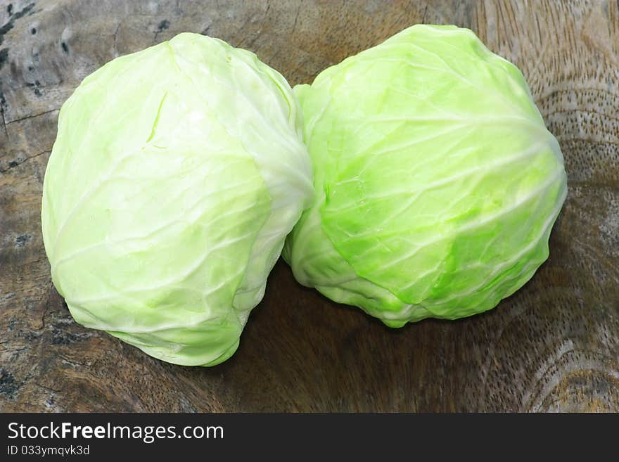 Green cabbage isolated on wood background