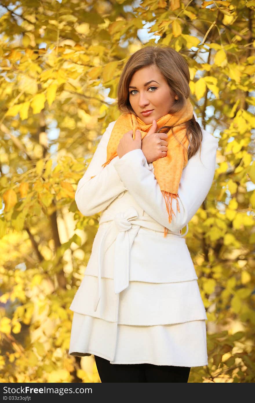 Attractive young woman in white coat outside. Attractive young woman in white coat outside