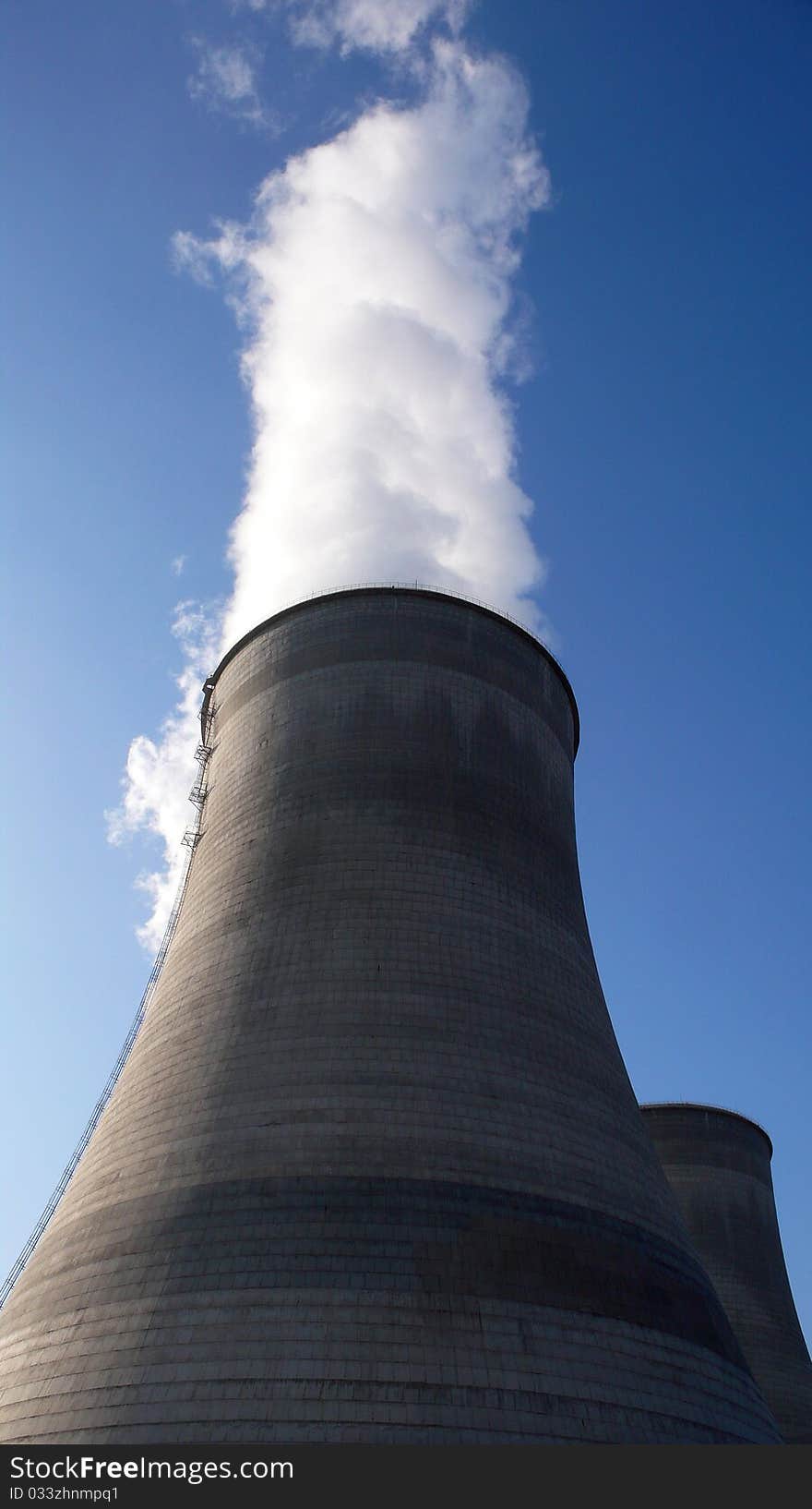 View of the big water towers in a heat power plant with blue skies as backgrounds