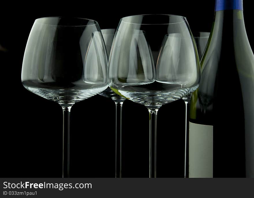 Wine glasses and wine bottle isolated over black background. Wine glasses and wine bottle isolated over black background