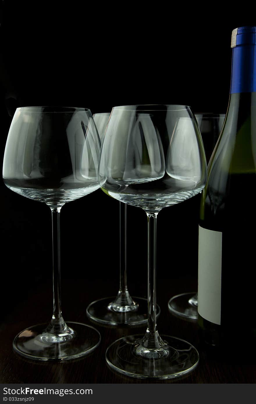 Wine glasses and wine bottle isolated over black background. Wine glasses and wine bottle isolated over black background