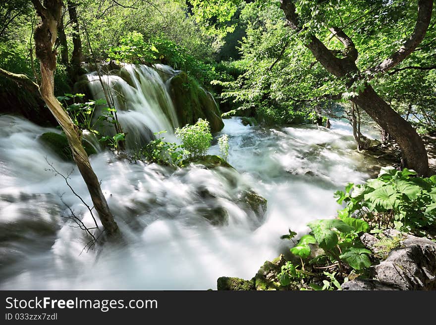 Waterfall and flowing water in a thick forest. Waterfall and flowing water in a thick forest