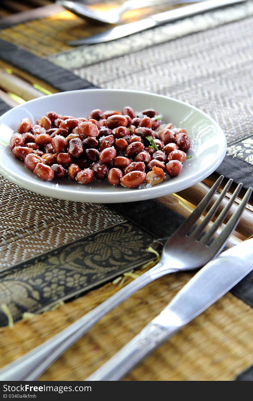 Peanuts on dining table as starter with knife and fork