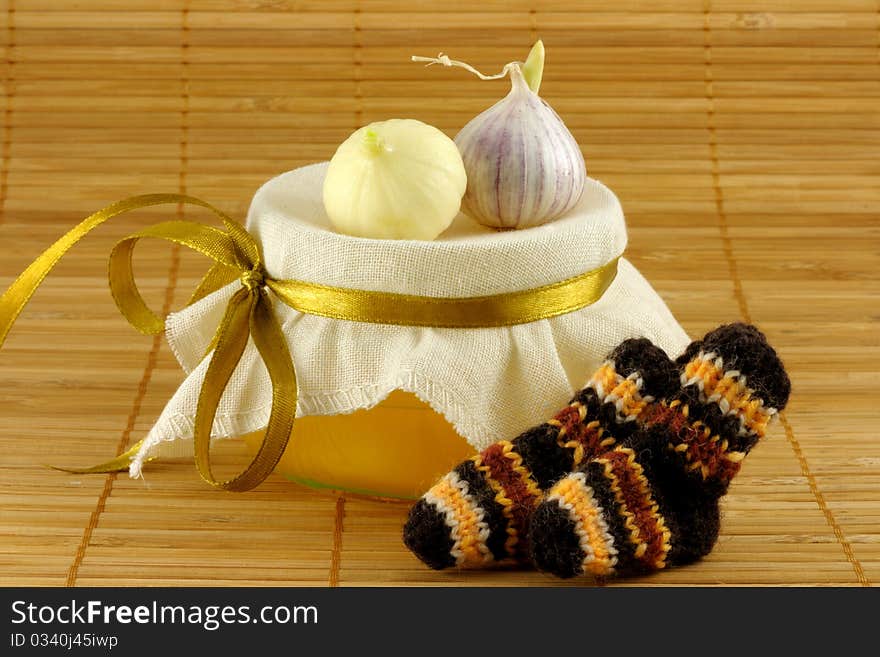 Honey, garlic, warm socks on a brown background