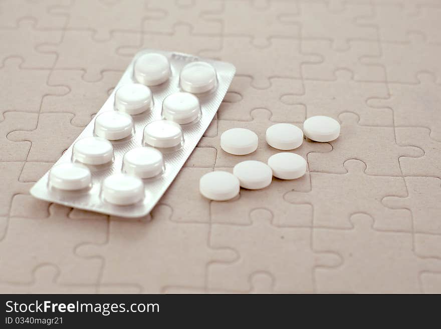 Plate of pills medicament on a gray background of the puzzle.