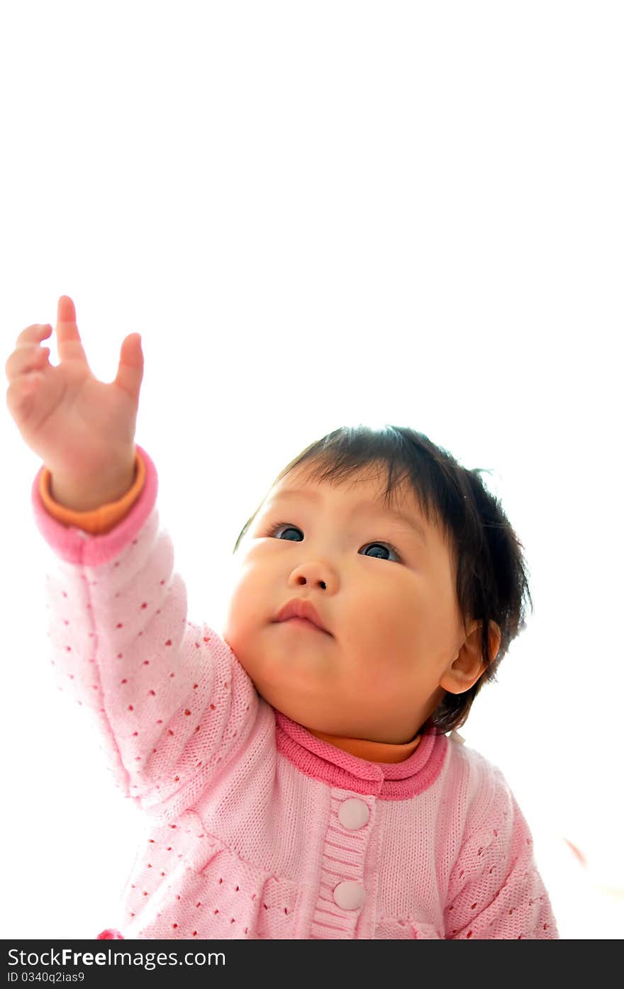 A Asian baby girl sitting on the bed。She wanted to catch a toy