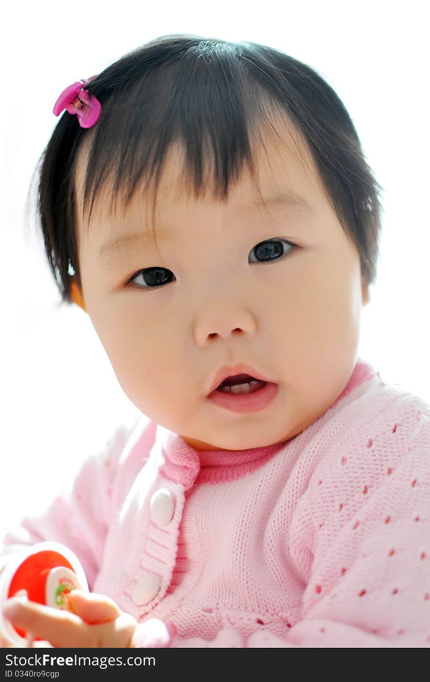 A Asian baby girl sitting on the bed