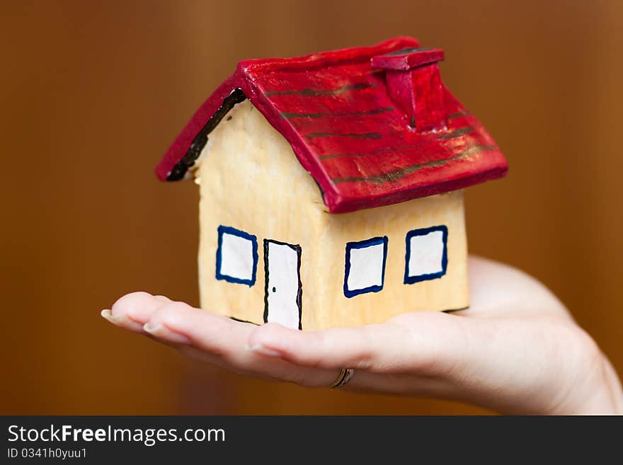 A woman holding a house in her hand