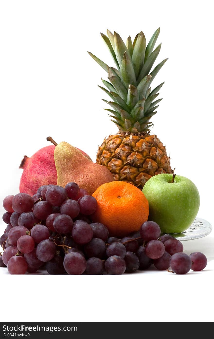 Dish with different fruit: pineapple, grapes, a pear, a tangerine, an apple on a white background separately. Dish with different fruit: pineapple, grapes, a pear, a tangerine, an apple on a white background separately