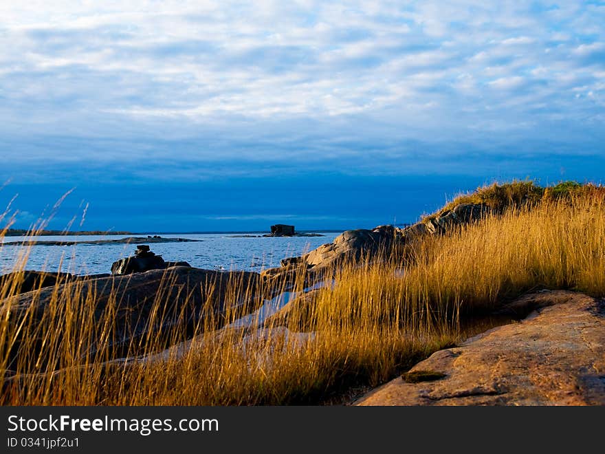 Rock with a yellow grass against the sea and the sky. Rock with a yellow grass against the sea and the sky