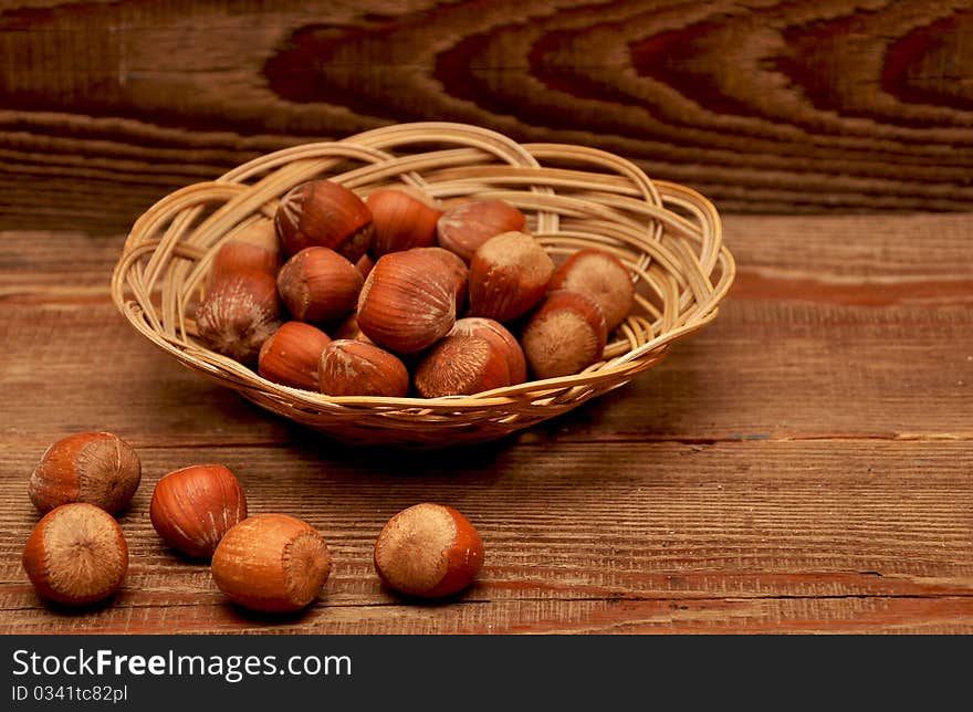 Wood nuts in a basket on wood background