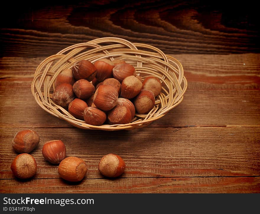 Wood nuts in a basket on wood background