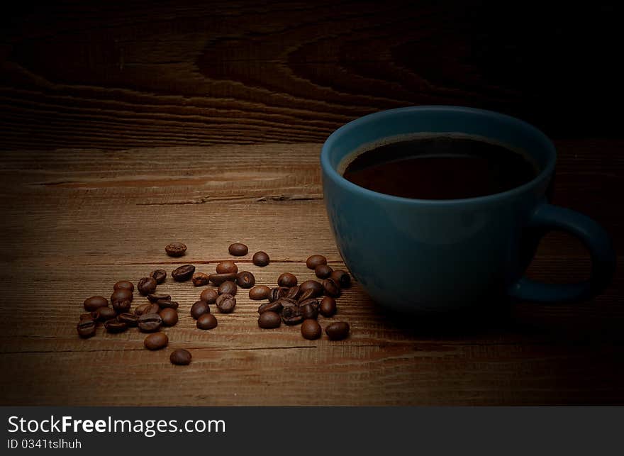 Grains and cup of coffee on wood background