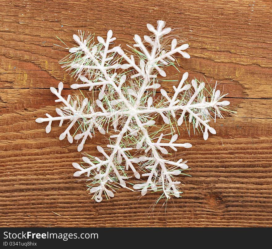 Closeup snowflake on wooden background