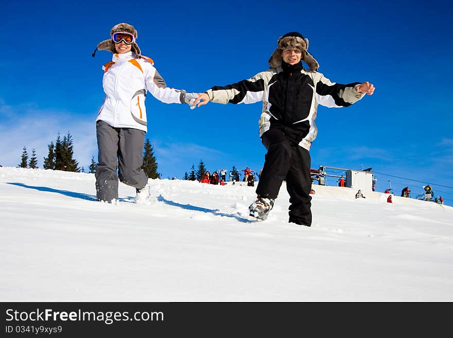 Happy skiers hurry on snow. Happy skiers hurry on snow