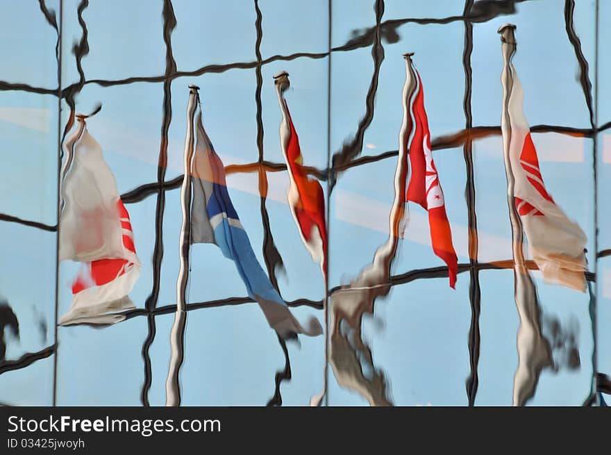 Flag image reflection on glass wall of building