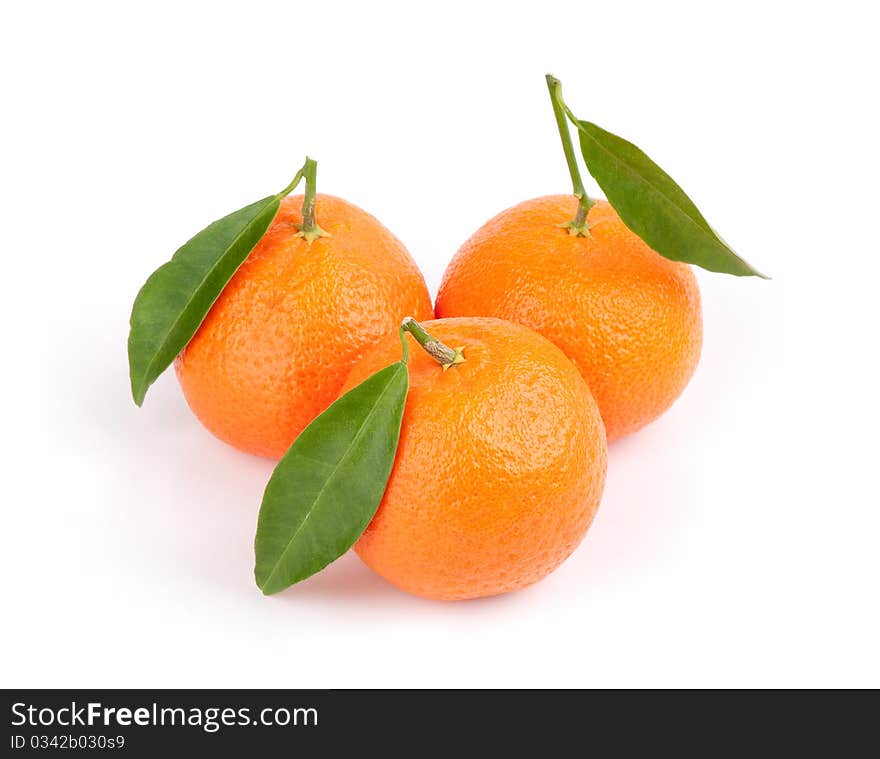 Three ripe tangerines with leafs