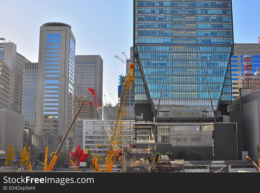 The picture illustrates crane and machinery being used for building skyscraper. The picture illustrates crane and machinery being used for building skyscraper