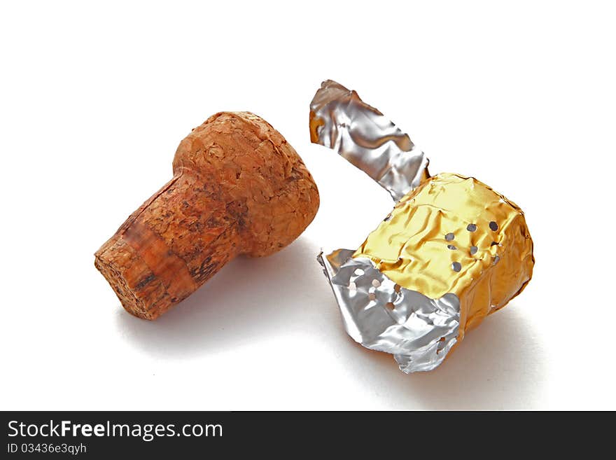 Champagne cork and foil on a plain white background.