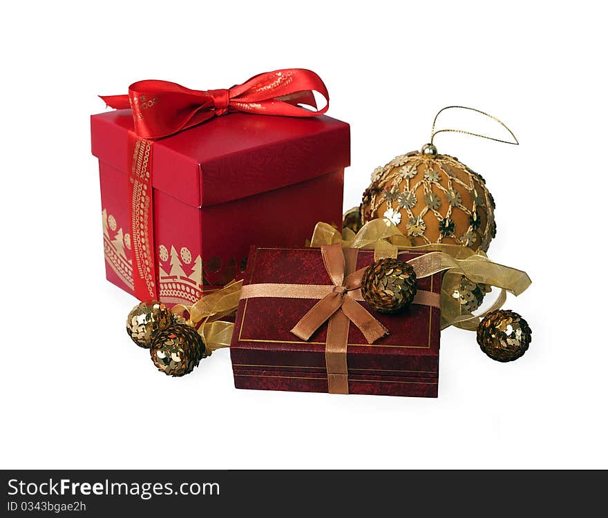 Red gift box with a satiny bow against gold Christmas-tree decorations