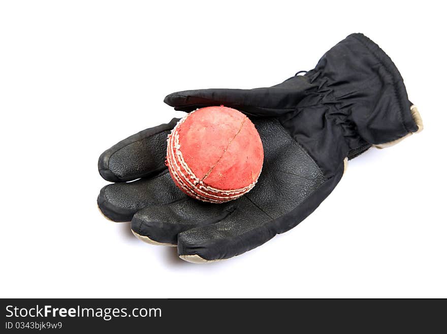 Leather cricket ball over leather glove isolated on white background. Leather cricket ball over leather glove isolated on white background.