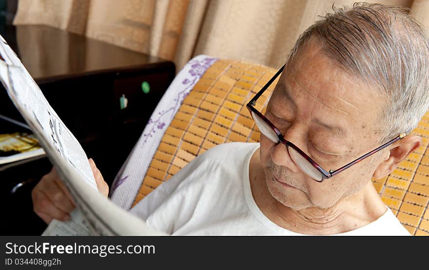 A senior man is reading newspaper