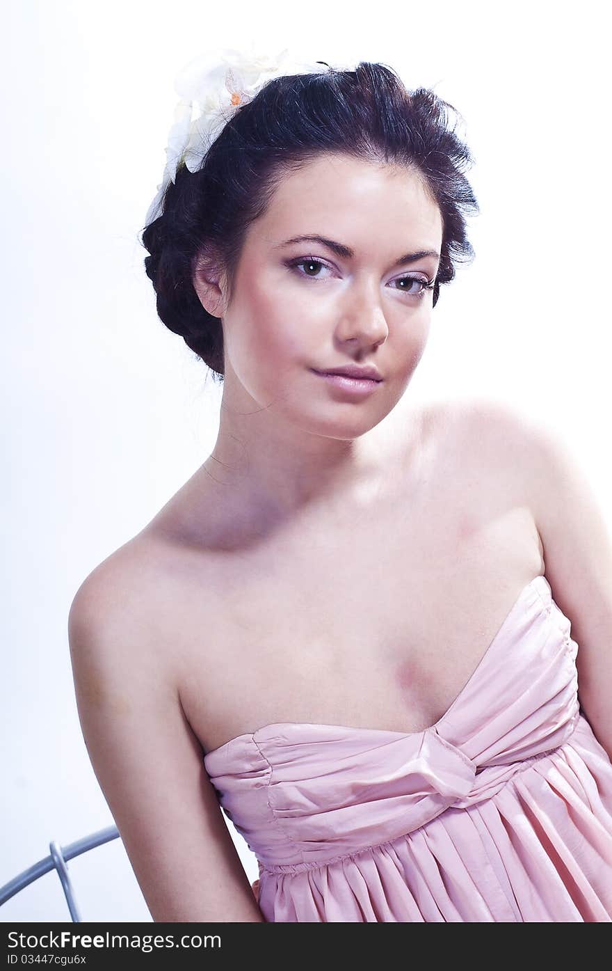 Studio portrait of a tender charming young girl in pink dress