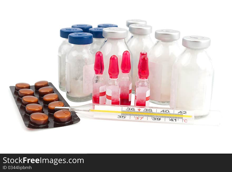 Ampoule, a thermometer and pills on a white background