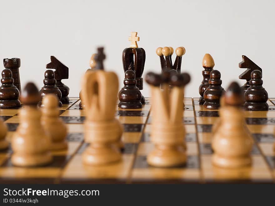 Figures of chess on the chessboard on the white background. Figures of chess on the chessboard on the white background