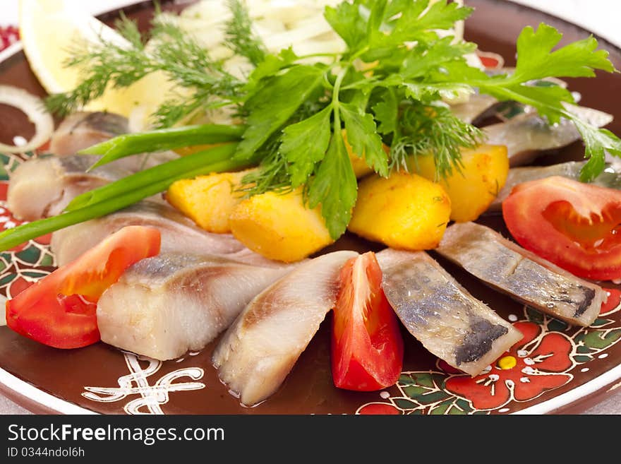 Herring with baked potato and tomatos Close-up