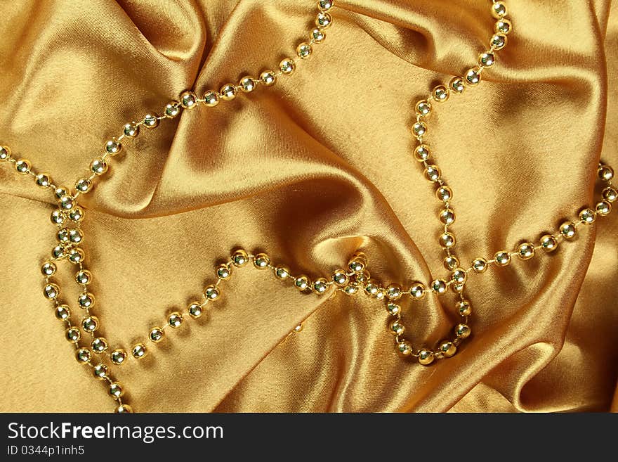 Background of gold cloth on which lay the golden beads. Background of gold cloth on which lay the golden beads