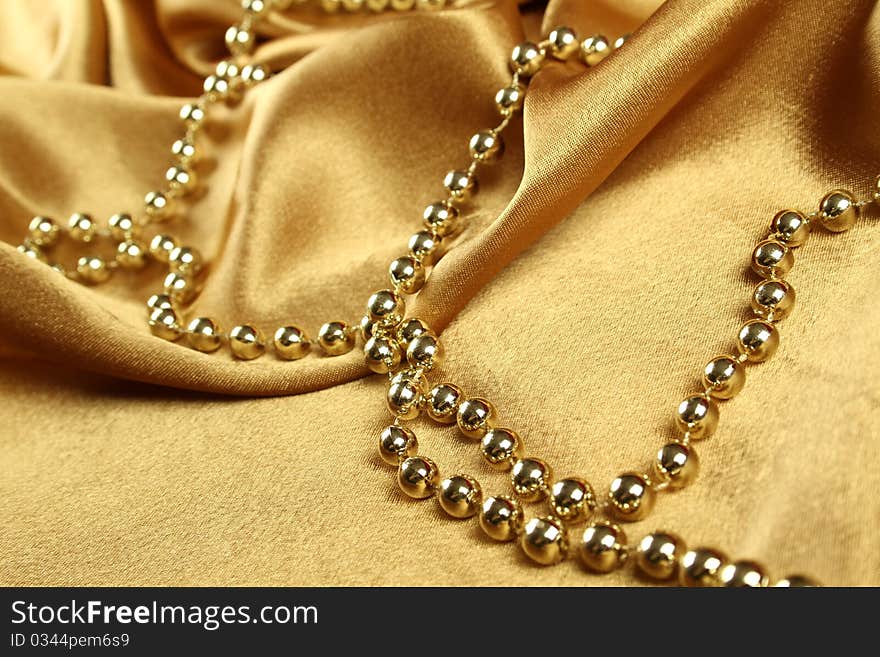 Background of gold cloth on which lay the golden beads. Background of gold cloth on which lay the golden beads