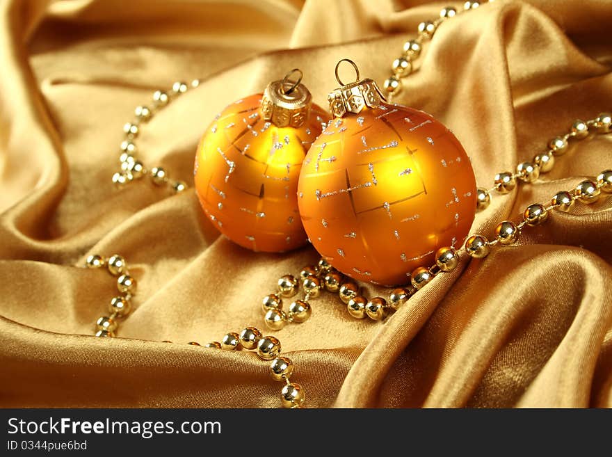 On gold fabric are gold ornaments and Christmas balls of yellow. Background. On gold fabric are gold ornaments and Christmas balls of yellow. Background